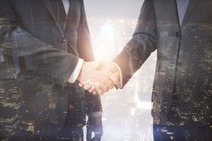 ATM company employee shaking hands with branch managers with a city a night overlayed